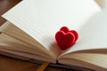 Couple little red hearts in a opened page of literature