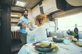 Couple living off grid inside a modern luxury camper van and enjoy travel lifestyle. People on vacation with home vehicle. Concept