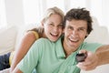 Couple in living room holding remote control