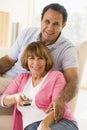 Couple in living room with remote control smiling Royalty Free Stock Photo