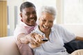 Couple in living room using remote control smiling