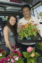 Couple Loading flowers into back of SUV portrait