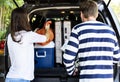 Couple loading luggage into a car