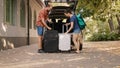 Couple loading vehicle trunk with luggage Royalty Free Stock Photo