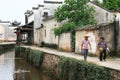 Couple of locals walk the stone pathway by the canal of an ancient village in Anhui province, China