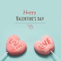 Lollipops pink candy on stick with Love text on blue . Valentine`s card