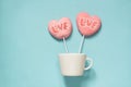 Couple lollipops pink candy on stick with Love text on blue. Balloon concept. Copy space.