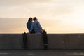 Silhouettes of young trendy man and woman with skateboards chilling look at embankment Royalty Free Stock Photo