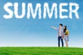 Couple look at cloud shaped summer text Royalty Free Stock Photo