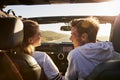 Couple look at each other while driving, rear passenger POV