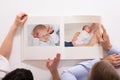 Couple Looking At Baby`s Photo Album