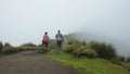 Couple looking backwards walking towards the summit of the Rucu Pichincha volcano on a cloudy day