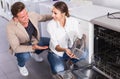 Couple looking at dishwashers in domestic appliances shop Royalty Free Stock Photo