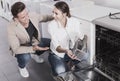 Couple looking at dishwashers in domestic appliances shop Royalty Free Stock Photo