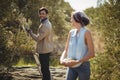 Couple looking at each other while collecting olives at farm Royalty Free Stock Photo