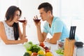 Couple looking at each other while drinking red wine in kitchen Royalty Free Stock Photo