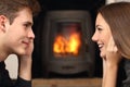 Couple looking each other in front a fireplace