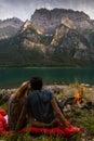 Couple looking at each other and relaxing in the front of a beautiful lake from Switzerland with fire beside.