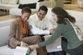 Couple Looking at fabric Swatches With Saleswoman in furniture store Royalty Free Stock Photo