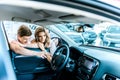 Couple looking at helm through open car window