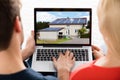 Couple Looking At House On Laptop