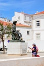 Couple by statue, Lagos, Portugal. Royalty Free Stock Photo