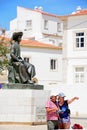 Couple pointing and statue, Lagos, Portugal.