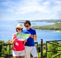 Couple Looking at Map by the Sea