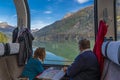 A couple looking out of the Bernina Express train of Rhaetian Railway Line to a lake on a autumn day,