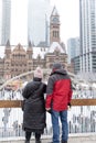 A couple looking over the ice skating rink at Nathan Philips Square and Old City Hall