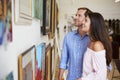 Couple Looking At Paintings In Art Gallery Together