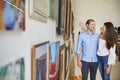 Couple Looking At Paintings In Art Gallery Together Royalty Free Stock Photo