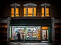 Couple looking in shop window lit up at night book store late opening covers with glowing windows romantic street scene browsing