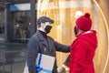 Couple looking at shopfront with protective masks