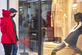 Couple looking at shopfront with protective masks