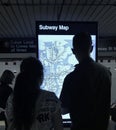 Couple Looking at Subway Information Digital Screen for Directions on NYC Subway Map MTA Train Station Royalty Free Stock Photo