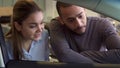 Couple looks inside the car at the dealership