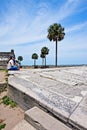 A couple looks sits on an embankment at Castillo De San Marcos while gazing on to Mantazas River