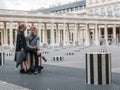 Couple lounges among the Colonnes de Buren, Palais Royal, Paris