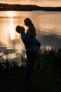 Couple in love back light silhouette at lake orange sunset Royalty Free Stock Photo