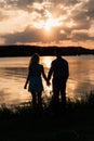 Couple in love back light silhouette at lake orange sunset Royalty Free Stock Photo