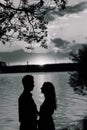 Couple in love back light silhouette at lake orange sunset Royalty Free Stock Photo