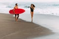 Couple in love on the beach with a surfboard at sunset. Beautiful couple on the island of Bali. Royalty Free Stock Photo