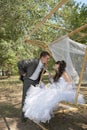 Couple in love bride and groom on swing in park