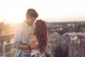 Couple in love on a building rooftop at sunset