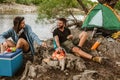 Couple in love camping forest hike. Food for hike and camping. Couple sit near bonfire eat and drink