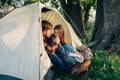 couple in love camping tent guy looks with love at the girl. Side view. Young family on vacation in the forest. Tourism
