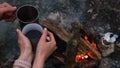 Couple in love Campsite With Fire Pit and Two Tin Cups with hot tea, coffee. Burning Campfire