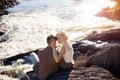 Couple in love close-up sitting on a stone on a beautiful Sunny day at sunset. Love emotions and hugs in the sun. Blonde woman Royalty Free Stock Photo