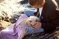 Couple in love close-up sitting on a stone on a beautiful Sunny day at sunset. Love emotions and hugs in the sun. Blonde woman Royalty Free Stock Photo